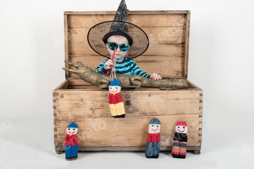 Preview: Happy Children In Elegant Green Clothes Play At Home With A Stuffed Crocodile And Rag Dolls. A Boy