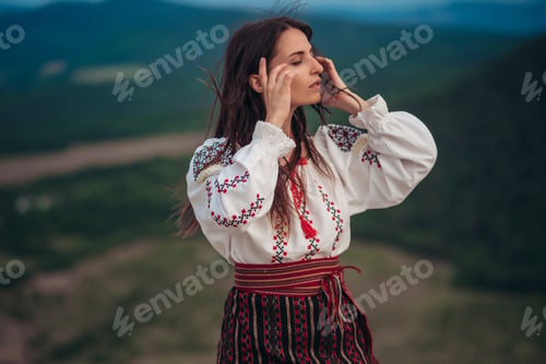 Preview: Attractive Woman In Traditional Romanian Costume On Mountain Green Blurred Background. Outdoor