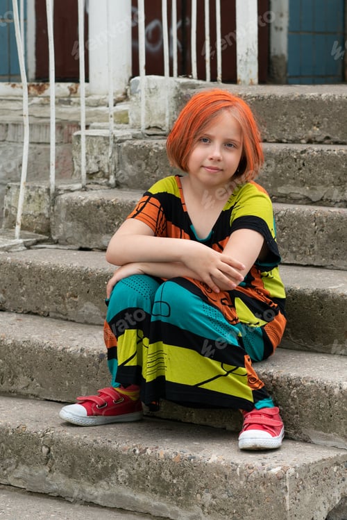 Preview: Little Girl Sitting On The Stairs In A Colored Dress