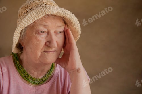 Aperçu: Portrait Of Elderly Woman In Pink T-Shirt With Beads, Straw Hat And Ornaments And Glasses