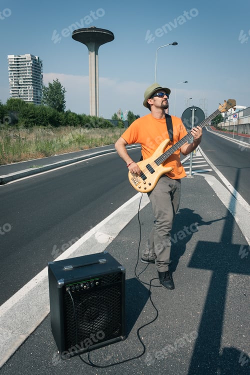 Preview: Young Musician Playing Bass Guitar In The Middle Of A Suburban Street