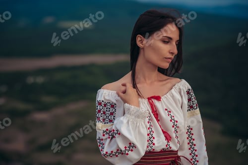 Preview: Attractive Woman In Traditional Romanian Costume On Mountain Green Blurred Background. Outdoor
