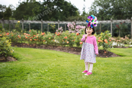 Preview: Toddler Girl Play Pinwheel In Summer Forest Park