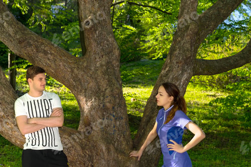 Preview: Sport Couple Of Youg Man And Woman Have A Conversation After Exercises In The Forest