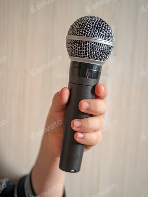 Preview: Funny Blond Boy In Big Eyeglasses Holds In His Hands Microphone For Karaoke. White Background