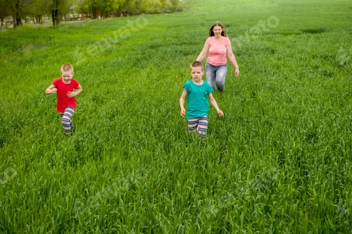 Preview: Happy Mother With Children Playing On A Green Field With Wheat. Unity With Nature Concept
