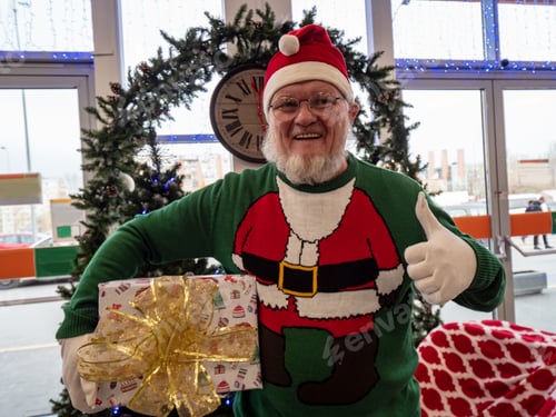 Preview: Elderly Man With Gray Beard And Mustache Wearing Santa Claus Hat And Carnival Clothes In Festive