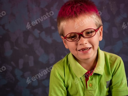 Preview: Cute Blond Child In Green Shirt And Glasses Posing In Front Of Camera And Smiling