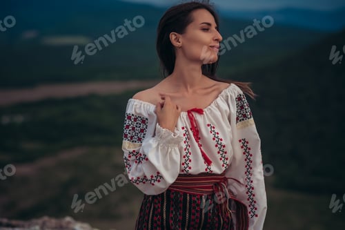 Preview: Attractive Woman In Traditional Romanian Costume On Mountain Green Blurred Background. Outdoor