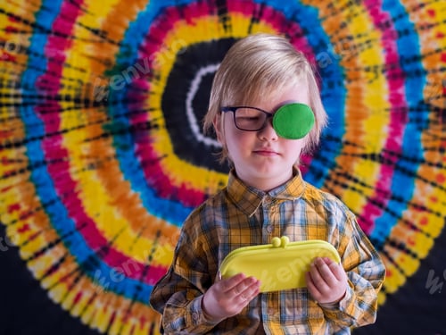 Preview: Portrait Of Funny Child In New Glasses With Green Spot To Correct Strabismus And Yellow Eyeglass