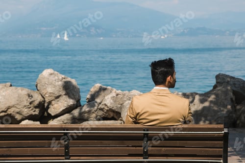 Preview: Man Sitting On A Bench And Looking At The Horizon. Concept Of Solitude And Depression.