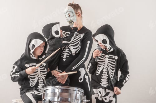 Preview: Happy Friendly Family Of Musicians In Carnival Costumes, Boys And Young Mother Play Drum And Try To