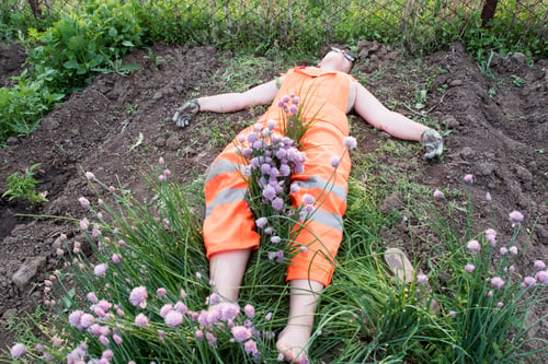 Preview: Slender Young Woman In Orange Working Overalls Cuts Onions For Salad With Scissors. The Girl Was