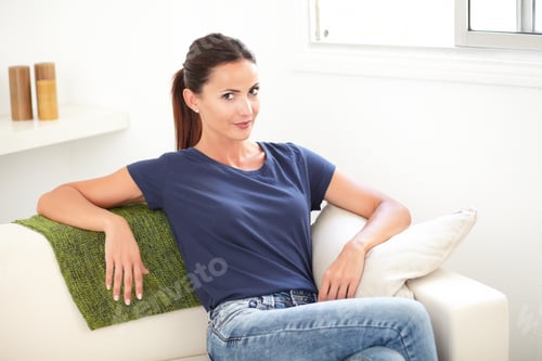 Preview: Woman Relaxing on a White Couch in Blue Shirt