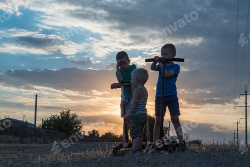 Preview: Happy Children With Their Father On A Walk In The Village. Boys Learn To Ride A Scooter On A Sunny