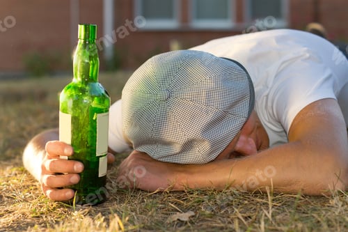 Preview: Drunk Caucasian Man Sleeping On The Ground Holding A Bottle Of White Wine
