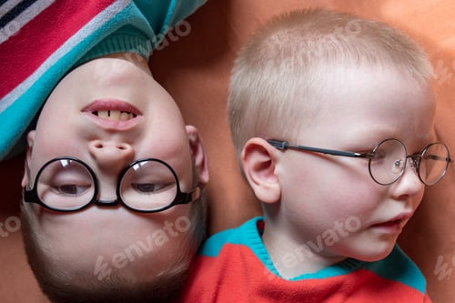 Preview: Two Brothers In Bright Colored Clothes Posing In Front Of Camera With Glasses For Vision. Children