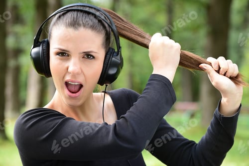Preview: Woman In Headphones. Emotional Young Woman In Headphones Listening To Loud Music And Screaming And