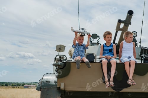 Preview: Three Children In Colorful Clothes Climbed Onto Modern Battle Tank. Children Play While No Tank