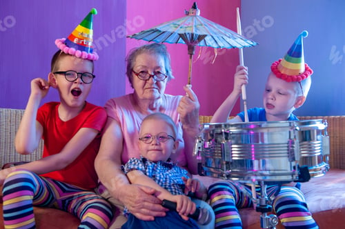 Preview: Elderly Woman In Pink T-Shirt And Glasses Holding Megaphone. Next To Grandmother, Grandchildren In