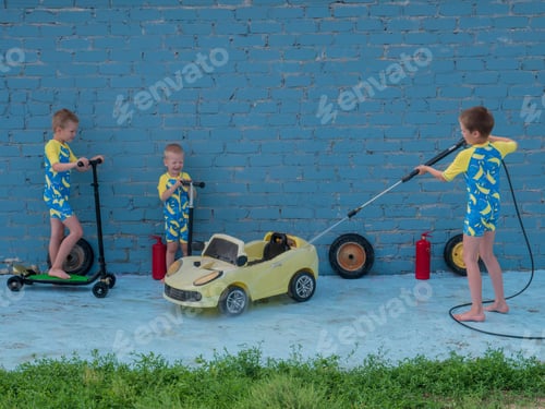 Preview: Funny Children In Boys' Bathing Suits Posing In Front Of Camera With High-Pressure Car Wash And Toy