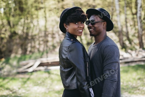 Preview: A Beautiful And Stylish Young African Couple In Sunglasses And Hats Embracing On A Outdoor Of Summer