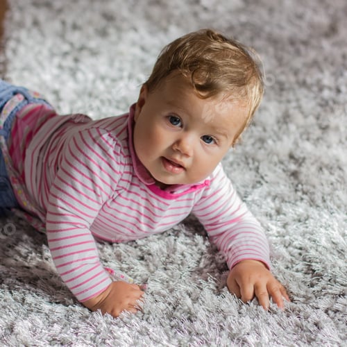 Preview: Portrait Of Adorable Baby Lying On Floor And Looking To Camera.