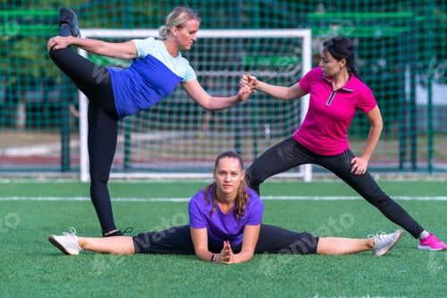 Preview: Three Young Woman Practicing Acrobatic Yoga Assuming A Choreographed Pose Outdoors On A Sports