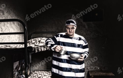 Preview: Angry Prisoner Wearing Prison Uniform Holding Aluminum Dishes Standing Near A Bunk Bed In A Prison