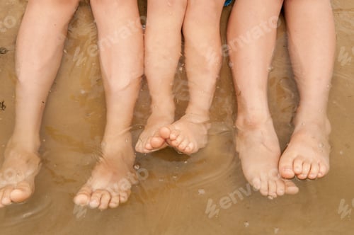 Preview: Funny Kids In Bathing Suits Sit Together On Sand With Their Legs In Water. Boys Are Happy On