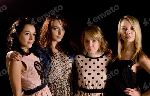 Preview: Four Stylish Young Teenage Girls On A Night Out Pose In A Line In Their Trendy Party Clothes On A