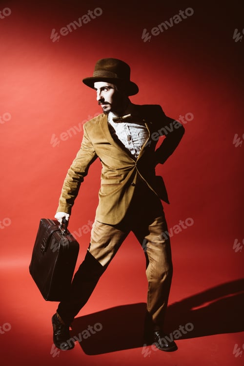 Preview: Man In Suit Posing In Studio With Suitcase In Hands
