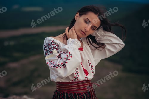 Preview: Attractive Woman In Traditional Romanian Costume On Mountain Green Blurred Background. Outdoor