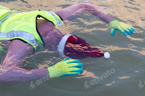Preview: Funny Farmer In Santa Claus Hat, Sunglasses, Reflective Jacket And Clean Green Gloves, Bathes In