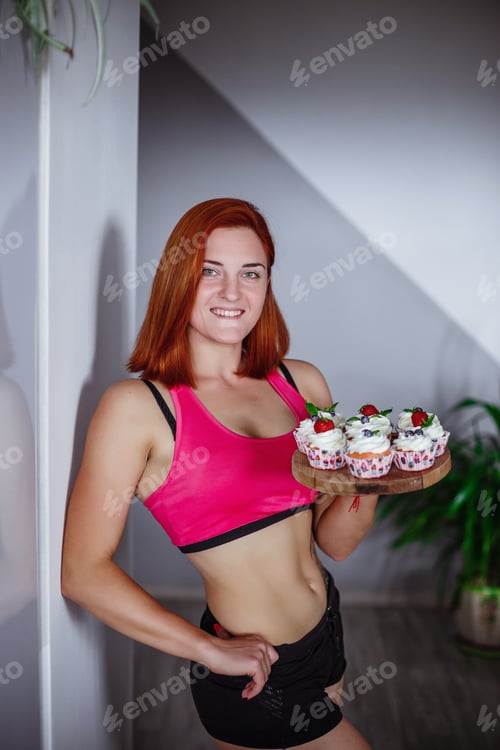 Preview: Fit Woman Holds Tray of Delicious Cupcakes Indoors