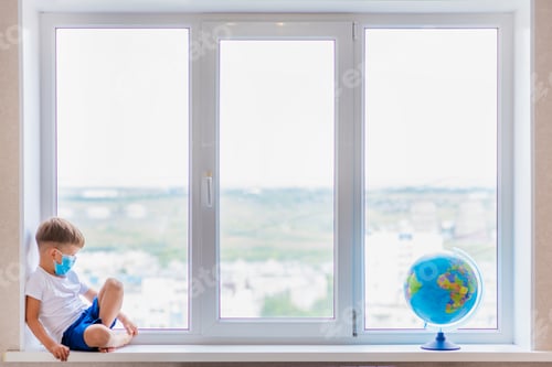 Preview: A Child In A Mask Sits At Home In Quarantine. The Child Studies The Globe While Sitting On The