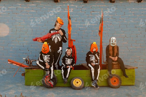Preview: Cute Family In Skeleton Costumes For Halloween Celebrations Are Playing Pirates On Wooden Sailing
