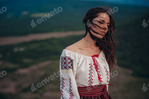 Preview: Attractive Woman In Traditional Romanian Costume On Mountain Green Blurred Background. Outdoor