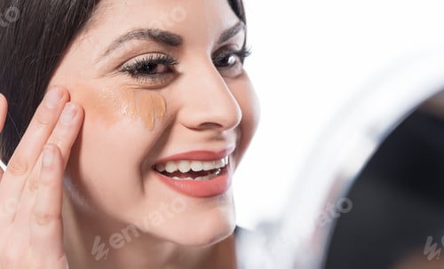 Preview: Close Up Of A Young Woman Applying Make Up Concealer On White Background