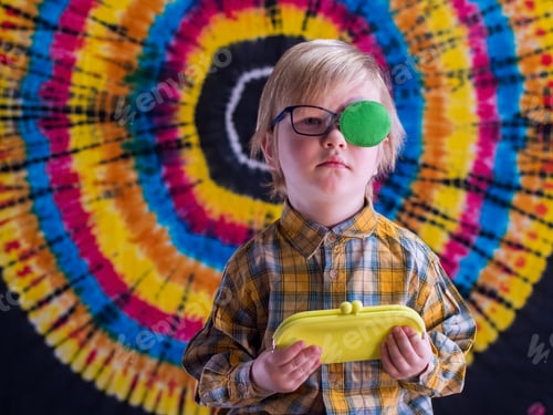 Preview: Portrait Of Funny Child In New Glasses With Green Spot To Correct Strabismus And Yellow Eyeglass