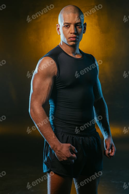 Preview: Serious Sportsman In Shorts And T Shirt Standing Alone And Clenching His Fists