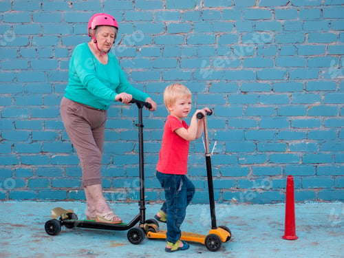 Preview: Elderly Grandmother In Turquoise Sweater Is Riding Scooter With Pretty Blond Grandson. Grandmother