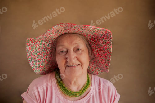 Preview: Portrait Of Elderly Woman In Pink T-Shirt With Decorations And Glasses. Pensioner Supports Health