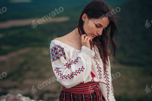 Preview: Attractive Woman In Traditional Romanian Costume On Mountain Green Blurred Background. Outdoor