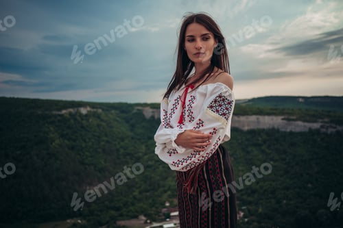 Preview: Attractive Woman In Traditional Romanian Costume On Mountain Green Blurred Background. Outdoor