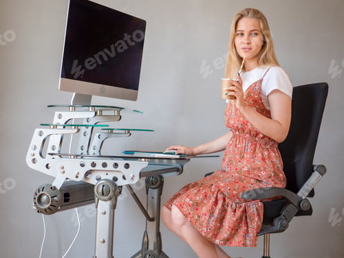 Preview: Slender Charming Blonde In White T-Shirt And Multi-Colored Sundress Poses In Front Of Camera In