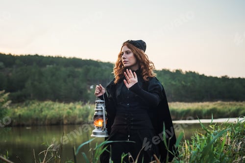 Preview: Witch With Light On A Swamp. Witch Practicing Magic On A Swamp. Halloween Concept