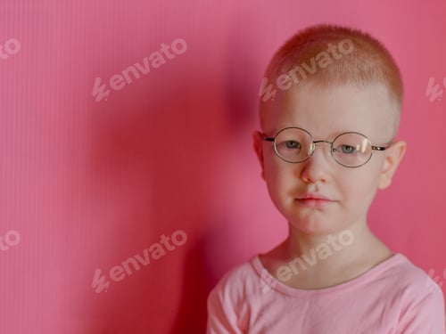 Preview: Portrait Of Funny Child In A Pink T-Shirt In New Glasses Is Playing With Computer Tablet On Pink