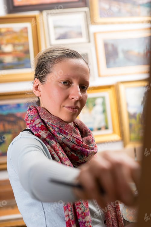 Preview: Portrait Of Female Painter Working On A Canvas On An Easel In A Studio Holding A Paintbrush