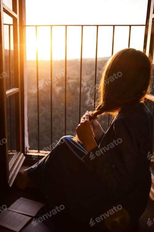 Preview: Girl Is Sitting On The Floor By The Open Window And Reading A Book